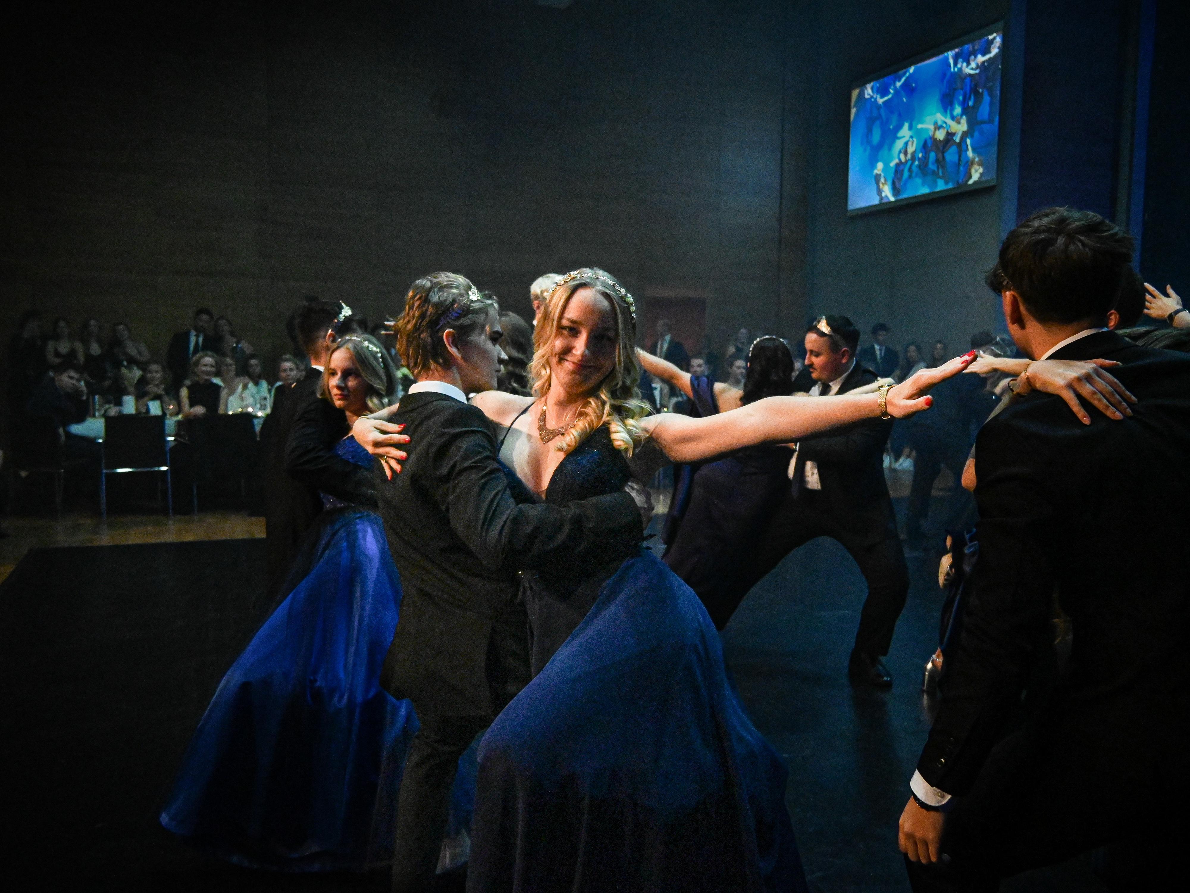 An elegant dance performance in a festive atmosphere. Dancers wear elegant outfits and showcase synchronized movements on stage.