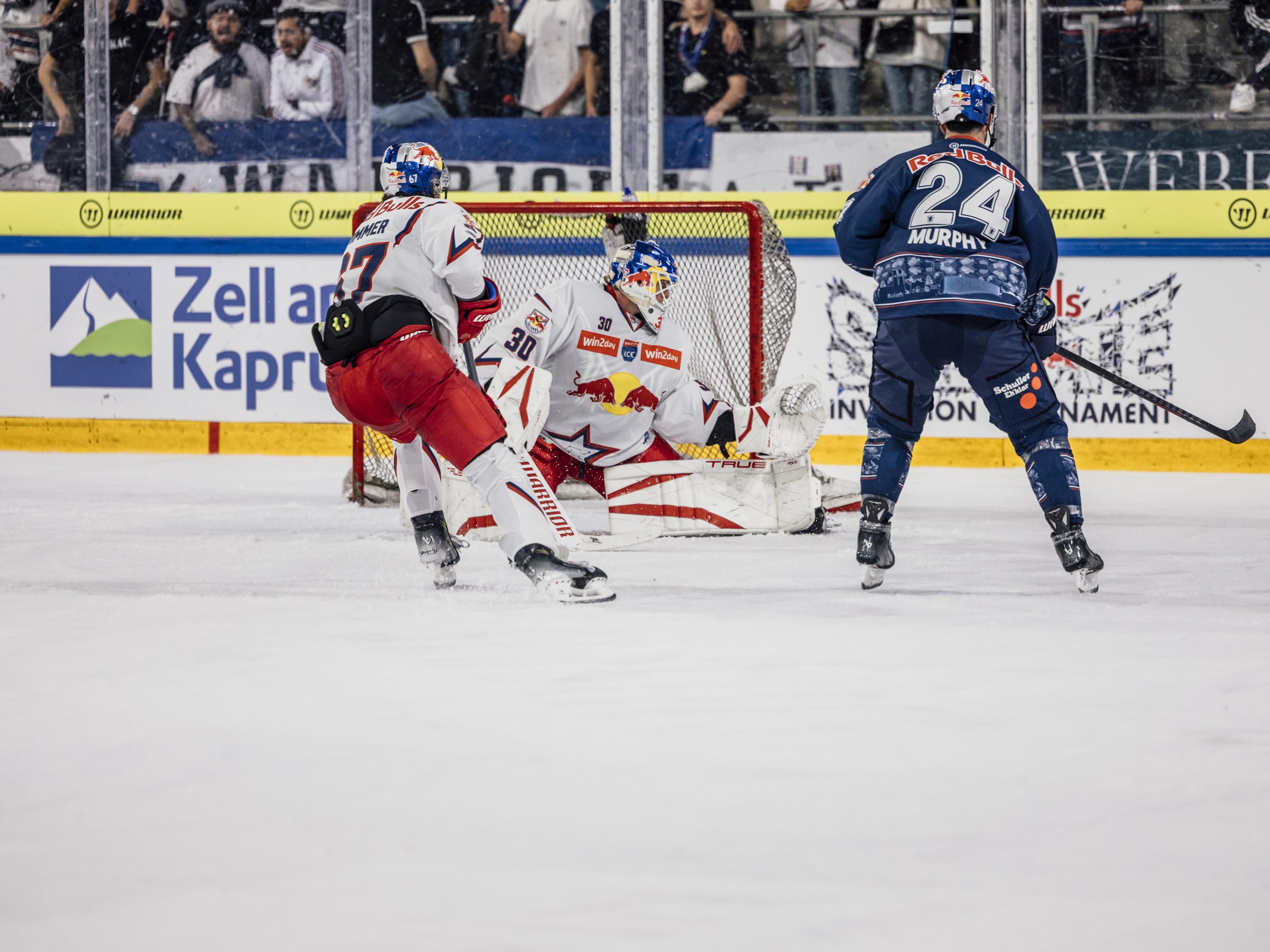 Ein spannendes Eishockeyspiel mit zwei Spielern auf dem Eis. Im Hintergrund ist das Publikum begeistert zu sehen.