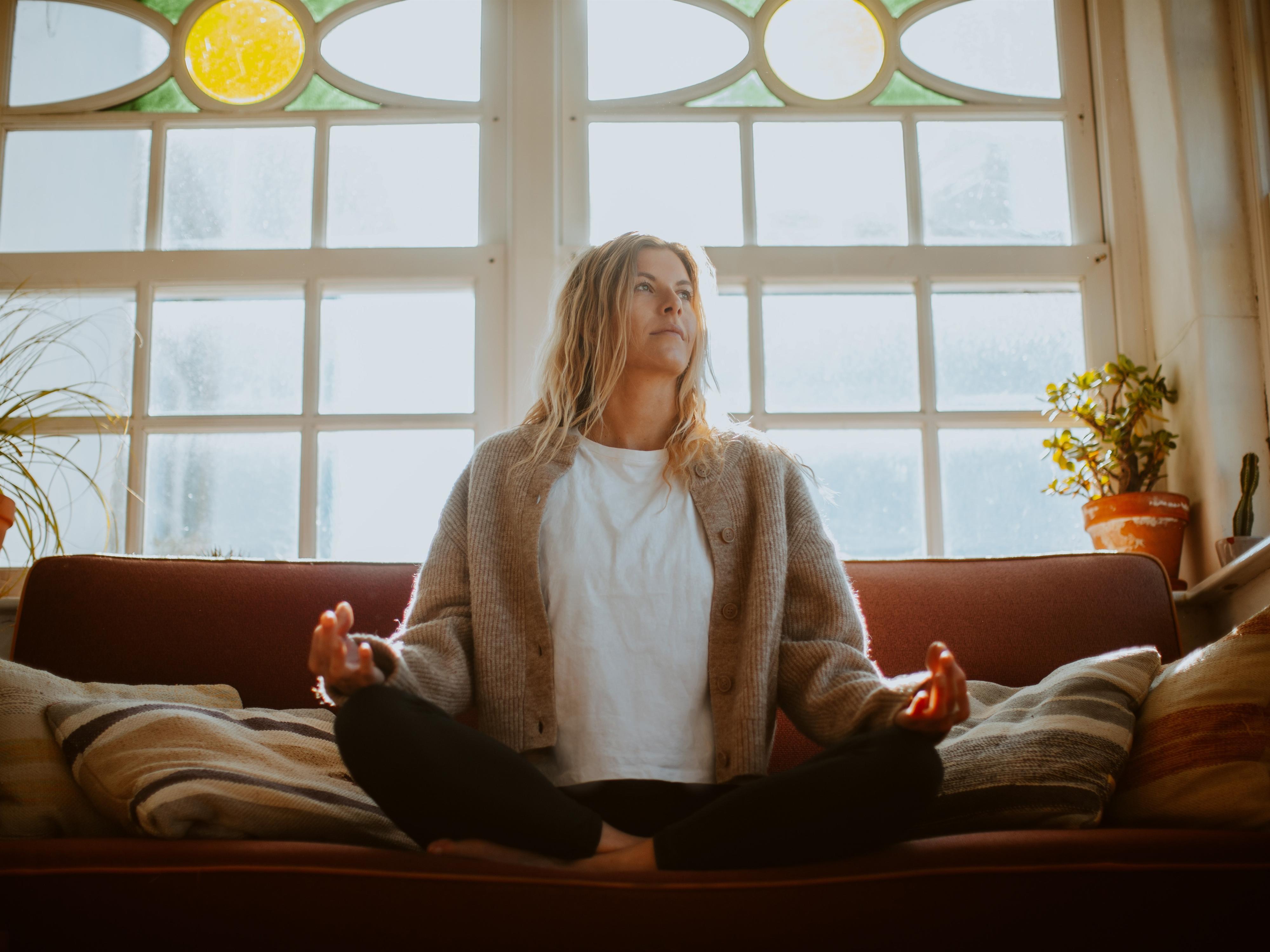 Eine Frau sitzt vor einem großen Gong und hält einen Farbwechsel-Glockenstock in der Hand. Sie trägt ein schwarzes Oberteil und lächelt freundlich.