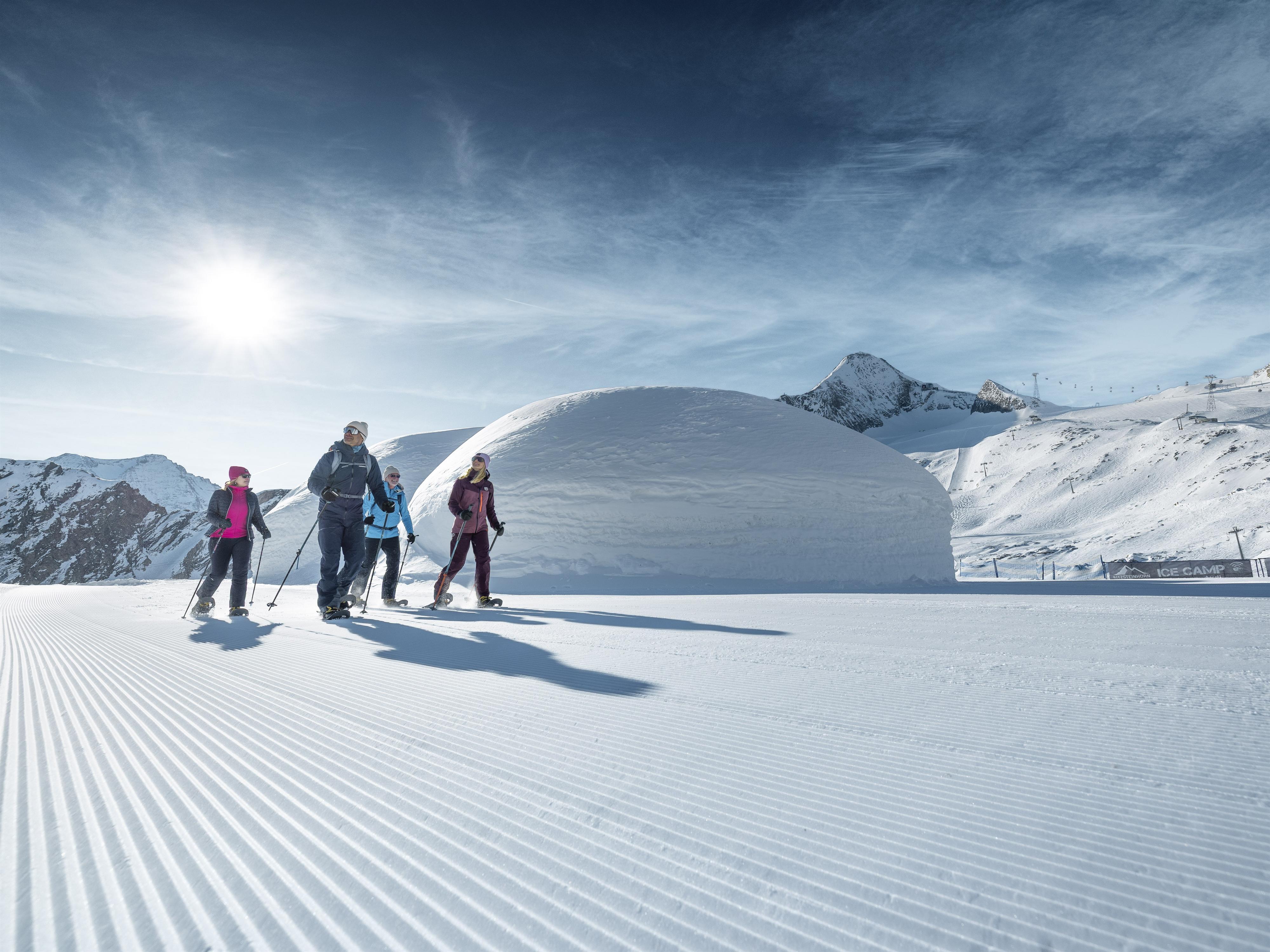 Eine Gruppe von Skifahrern genießt die sonnige Berglandschaft. Der Schnee ist frisch und die Aussicht ist beeindruckend.