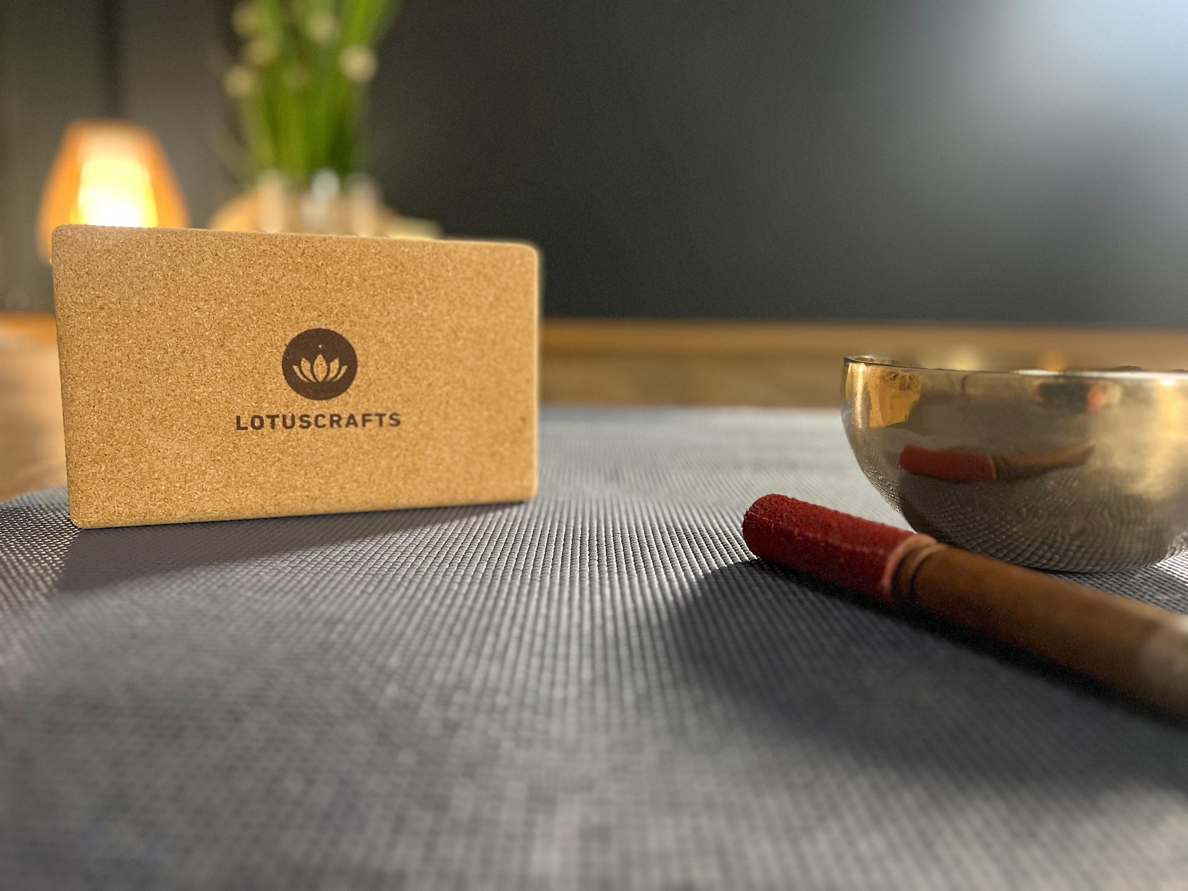 Eine Frau sitzt vor einem großen Gong und hält einen Farbwechsel-Glockenstock in der Hand. Sie trägt ein schwarzes Oberteil und lächelt freundlich.