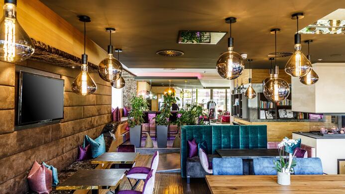 A modern restaurant with stylish interior design. Cozy seating areas and beautiful lighting create an inviting atmosphere.